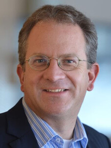 Porträtfoto Roderich Moessner mit Brille und Anzug, freundlich und professionell.